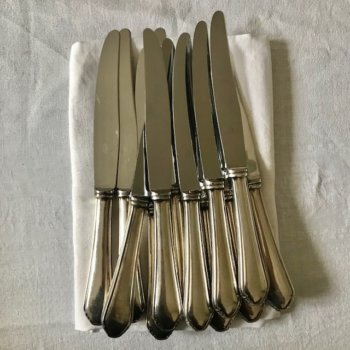 Doce cuchillos de metal plateado