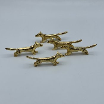 Cinq porte couteaux en métal doré, en forme de bassets ou corgis